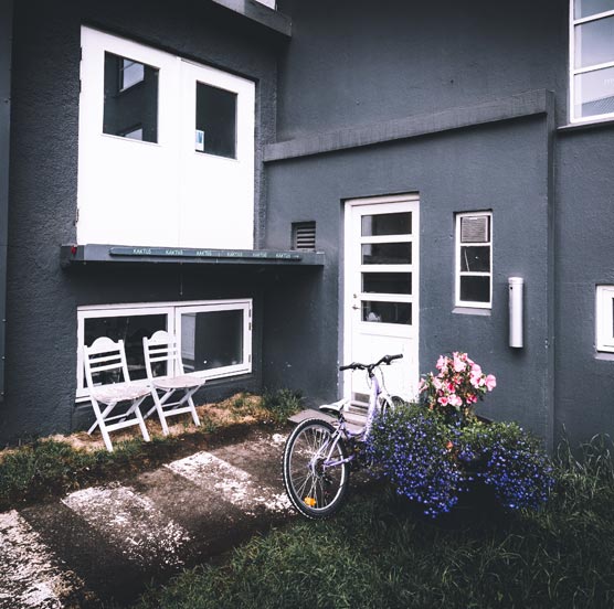 A bicycle stands parked in front of a house, highlighting a serene neighborhood atmosphere.