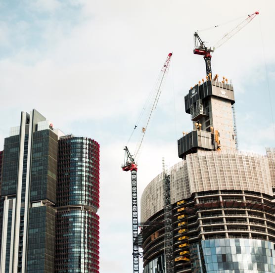 A bustling construction site with laborers and machinery involved in the ongoing building project.